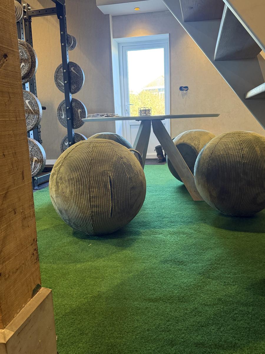 Zithoek met grote zitballen en een ronde tafel bij de deur